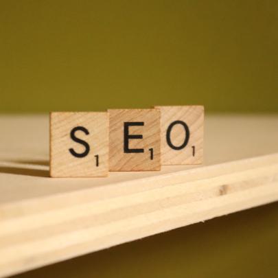 three wooden blocks sit on a table. The blocks spell out SEO